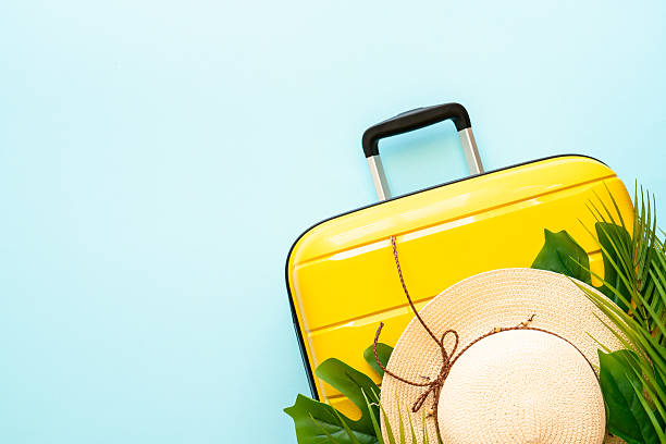 istock Suitcase, hat and flip flops on blue background. 2216239377