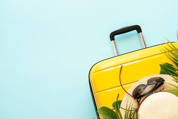 istock Suitcase, hat and sunglasses on blue background. 2216239390