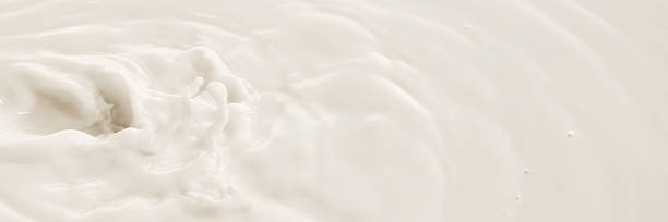 White milk swirls in soft circular motion with textured surface and natural flow.