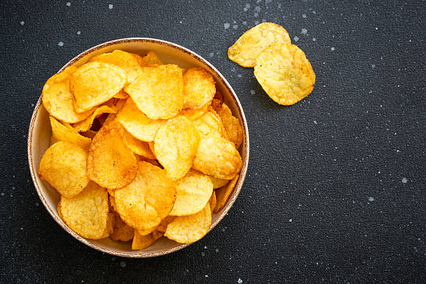 istock Potato chips and ketchup on black table. Top view. 2216243375