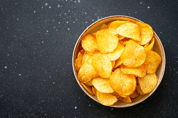 istock Potato chips and ketchup on black table. Top view. 2216243396