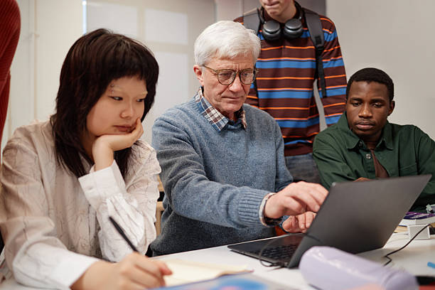 istock Professor Pointing at Laptop Screen with Students Watching 2216244714