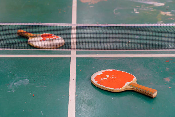 An Asian man is coaching female student playing table tennis