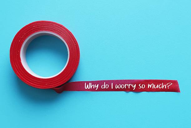 istock Red tape on blue background with text written - Why do I worry so much? - when worries, doubts and anxieties becomes excessive, persistent and uncontrollable. Can't get anxious thoughts out of head 2216245406