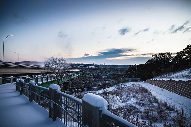 istock Snowy bridge and distant city skyline at dusk. 2216245896