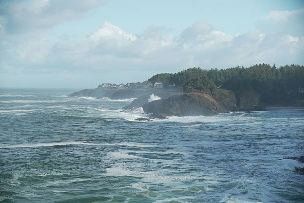 Aerial drone footage of the Pacific Ocean from above, the churning water a beautiful blue green as the waves surge and crash.