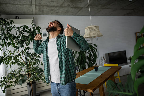 istock Excited freelancer celebrating success working from home 2216251800