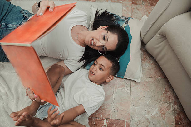 Asian mother working with her child on renewable energy project for school science class at home - Focus on windmill drawing - Black and white editing