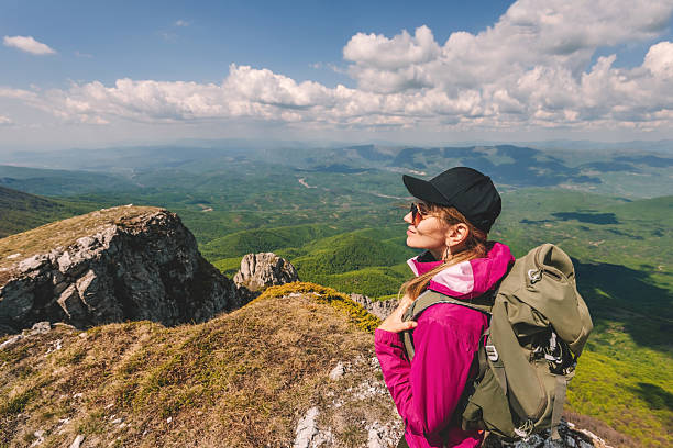 istock Woman Traveler with Backpack Hiking in Mountains 2216257199
