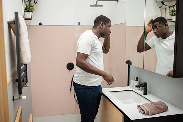 istock Man Looking at Himself in Mirror During Morning Routine 2216261792