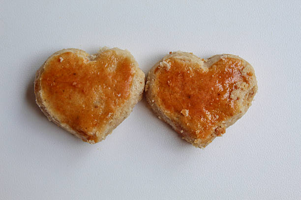 Two peanut cookies in love shape, isolated on white background, flat lay or top view