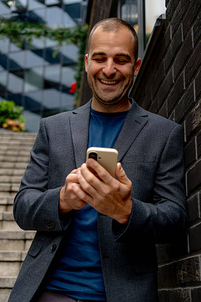 istock Businessman using smartphone and smiling in the city 2216267625