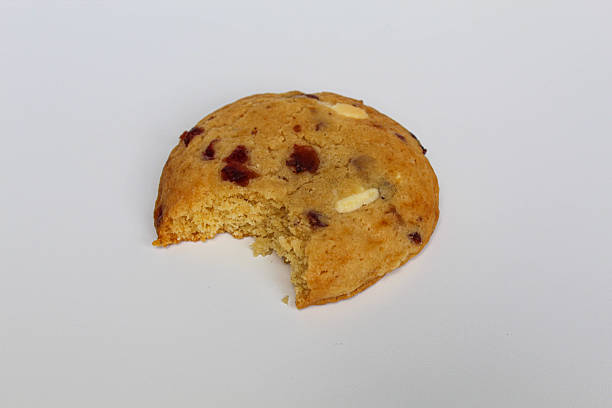 istock A bitten white choco soft cookie with almond and berry cuts, isolated on white background 2216269923