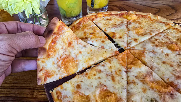 Delicious Thin Crust Cheese Pizza Cut Into Eight Slices on a Wooden Table, A delectable thin crust cheese pizza featuring eight neatly cut slices served on a rich wooden table background.