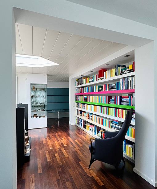 istock Library, long fully packed  colorful bookshelves with armchair 2216272907