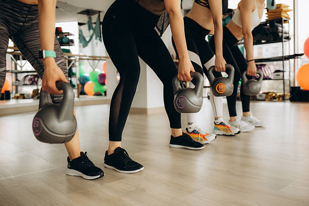 istock Group of Women Exercising Together Using Kettlebells in a Modern Gym Environment 2216274470