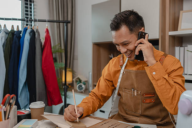 istock designer proudly presents his excellent design work to a client, a tailor is explaining the design concept of a new collection to investors so they can understand to convey through his designs. 2216274719