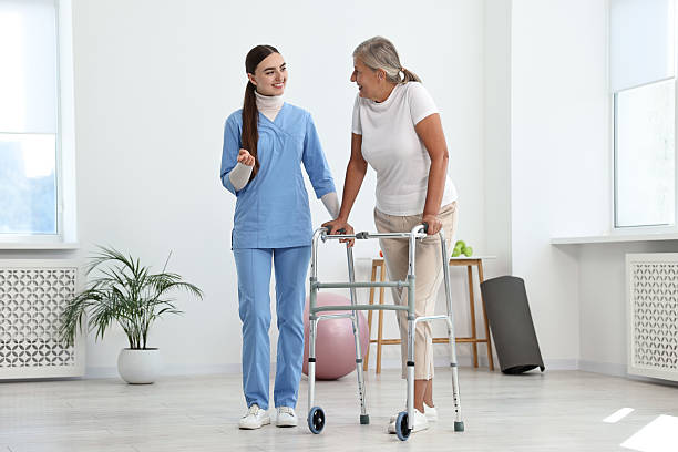 istock Nurse helping senior woman with walking frame in clinic 2216275621