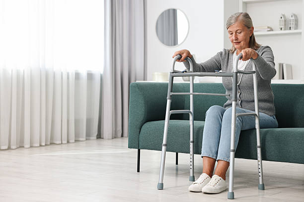 istock Senior woman with walking frame on sofa at home, space for text 2216275786