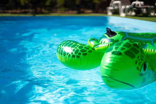 Green inflatable turtle floating in a sparkling blue swimming pool, perfect for summer fun