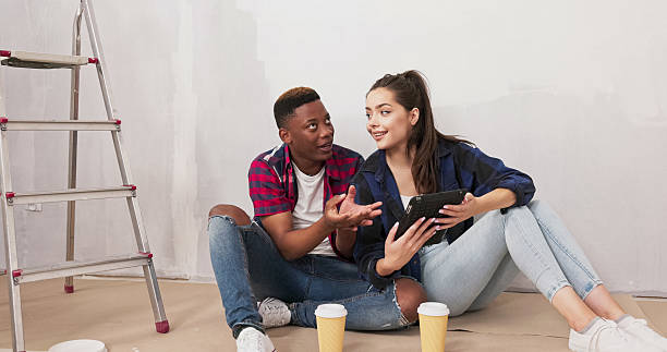 istock During their home renovation, a loving couple takes a break, drinking takeaway coffee, browsing a tablet for landscaping ideas, and smiling at the camera, excited for their project. 2216280016