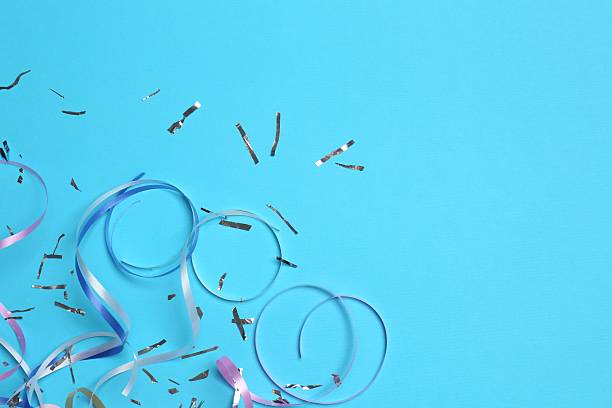 istock Shiny confetti and party streamers on light blue background, flat lay. Space for text 2216280705