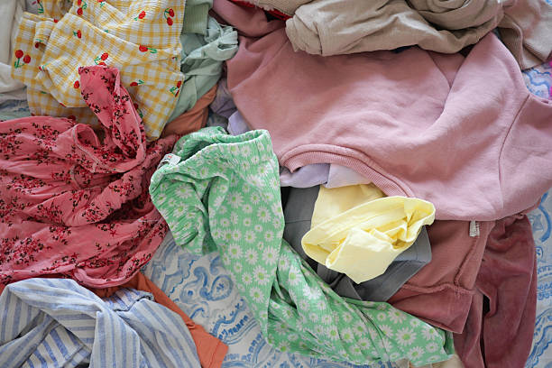 istock Clothes piled on a bed after laundry day in natural light 2216280934