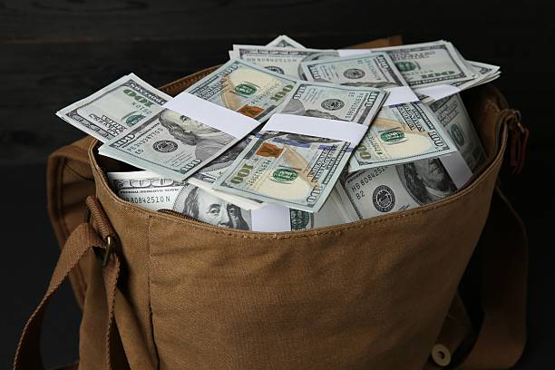 Dollar banknotes in bag on table, closeup