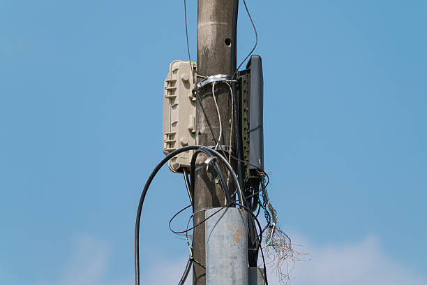 Old low tension electrical pole on blue sky