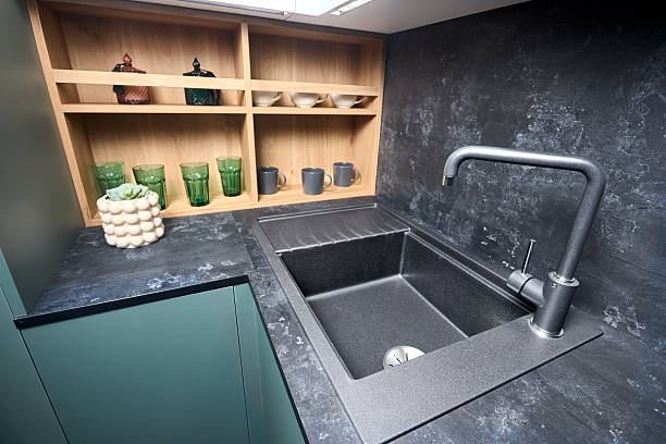 istock Interior of contemporary green and red kitchen. Luxury modern fitted flat design kitchen with square stoneware sink and tap wooden shelves cupboard sideboard with dish drying cabinet vertical shot. 2216286019