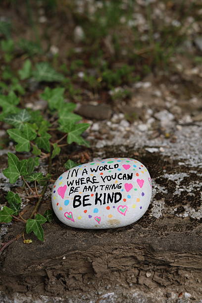 istock Mossy stone with vine and be kind kindness rock vertical photo 2216286967
