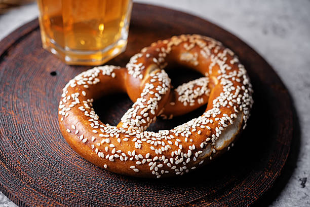 Close up of delicious golden brown pretzels topped with a sprinkle of salt, beautifully presented in a glass showcase at a charming bakery in Paris