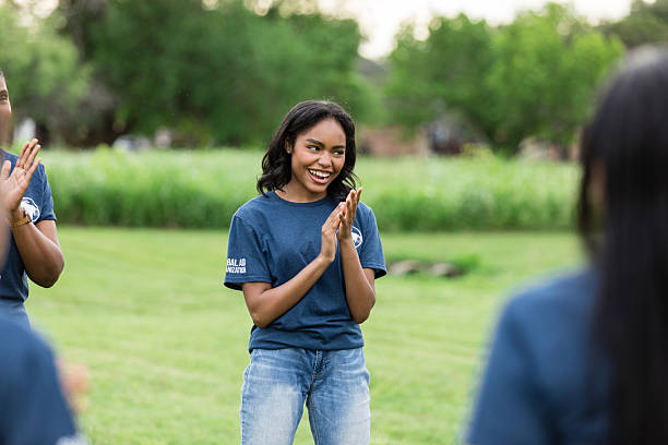 istock Cheerful young woman clapping in a group outdoors 2216289044