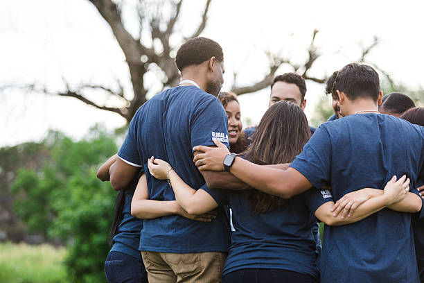 istock Group of diverse people embracing outdoors, showing teamwork and togetherness 2216289052
