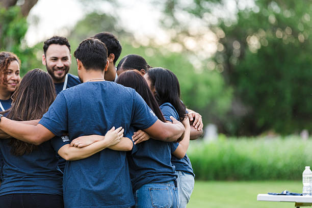 istock Diverse Group of Adults Embracing in Teamwork and Unity 2216289075