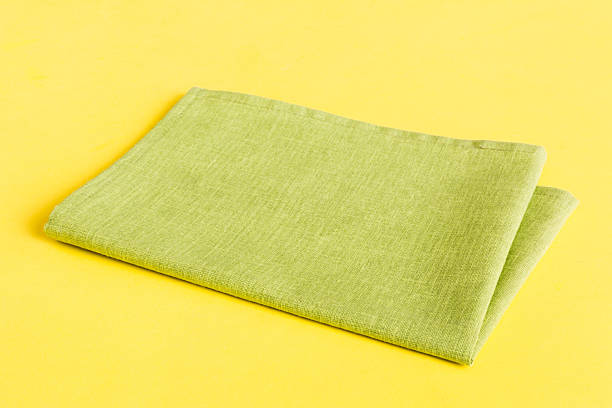 istock top view with green kitchen napkin isolated on table background. Folded cloth for mockup with copy space, Flat lay. Minimal style 2216292784