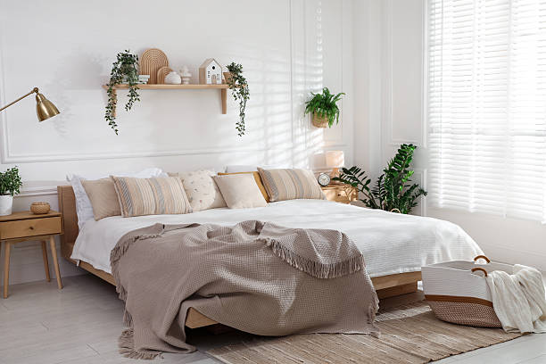 istock Stylish bedroom interior with large bed, houseplants and decorative elements 2216294207