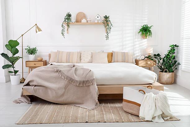 istock Stylish bedroom interior with large bed, houseplants and decorative elements 2216294209
