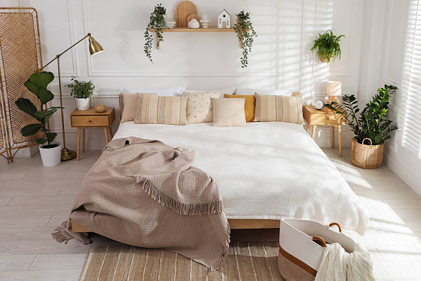 istock Stylish bedroom interior with large bed, houseplants and decorative elements 2216294226