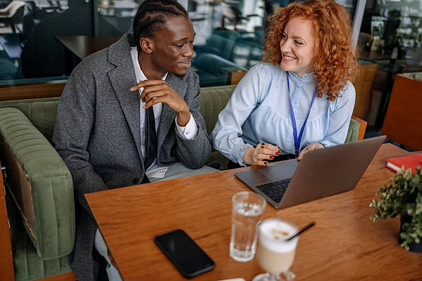 istock Businesswoman meeting with client at cafe having relaxed talk while using laptop 2216294536