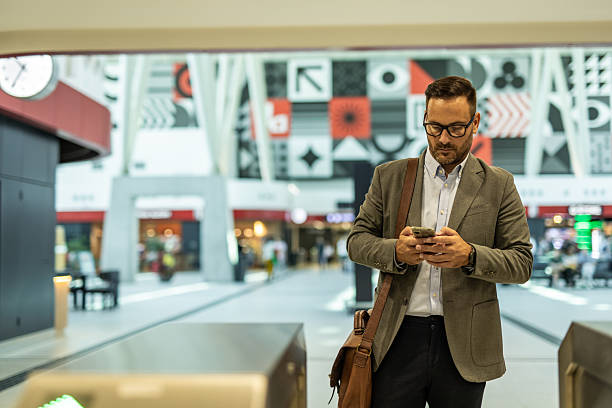 istock Businessman using smartphone in modern airport terminal 2216295991