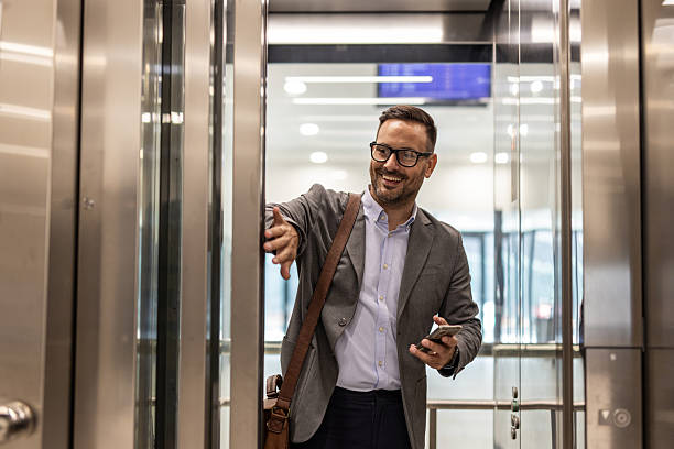 Businessman holding elevator door open for someone