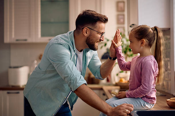 istock Happy father and daughter giving high-five at home. 2216296419