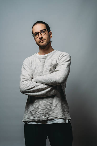 Portrait of a young, confident businessman crossing his arms and gazing directly at the camera, exuding an air of determination and professionalism