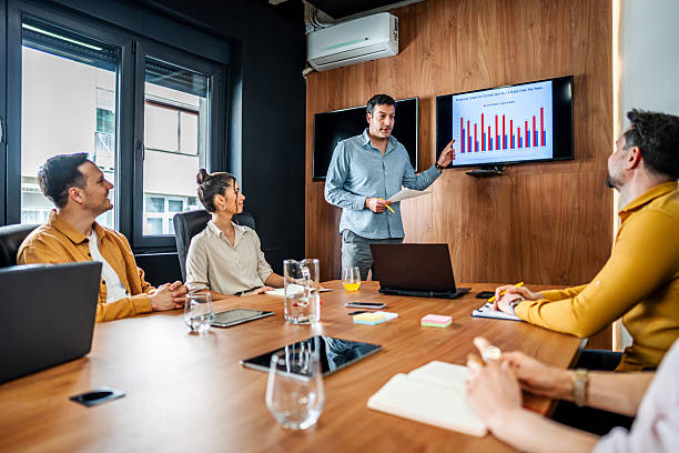 istock Manager using digital screen presenting business strategy to coworkers in meeting room 2216300042