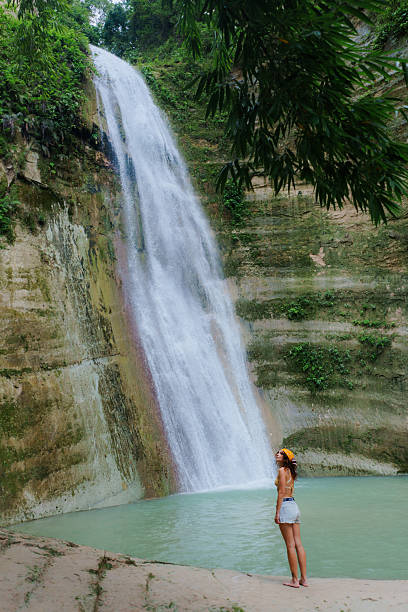 istock Woman looking with awe at tropical waterfall on Cebu island 2216303844