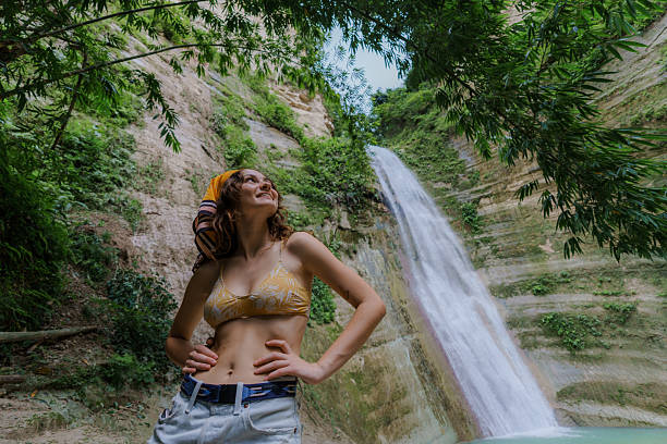 Woman looking with awe at tropical waterfall on Cebu island  during trip to Philippines