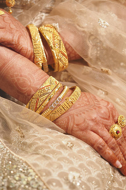 istock Elegant golden bangles on adorned hands at a cultural celebration 2216304200