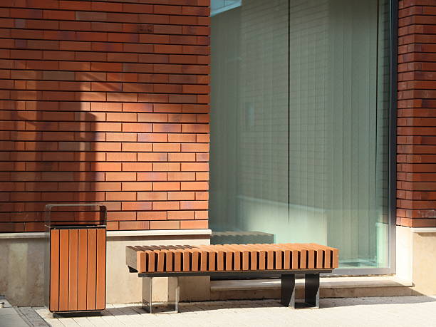 istock A Modern Urban Bench and a Trash Bin positioned beautifully Against a Brick Wall 2216304201