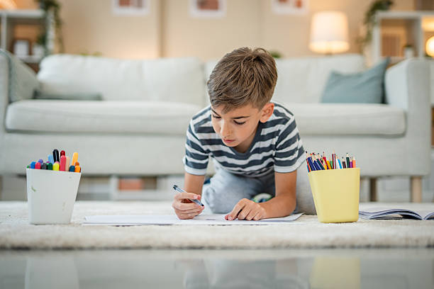 istock One boy drawing at home on the floor 2216308191